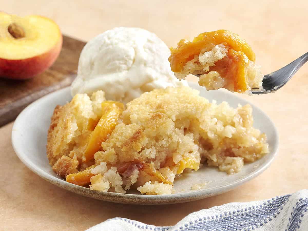 Seitenansicht auf einen Teller mit Pfirsichschuster mit einer Kugel Vanilleeis.
