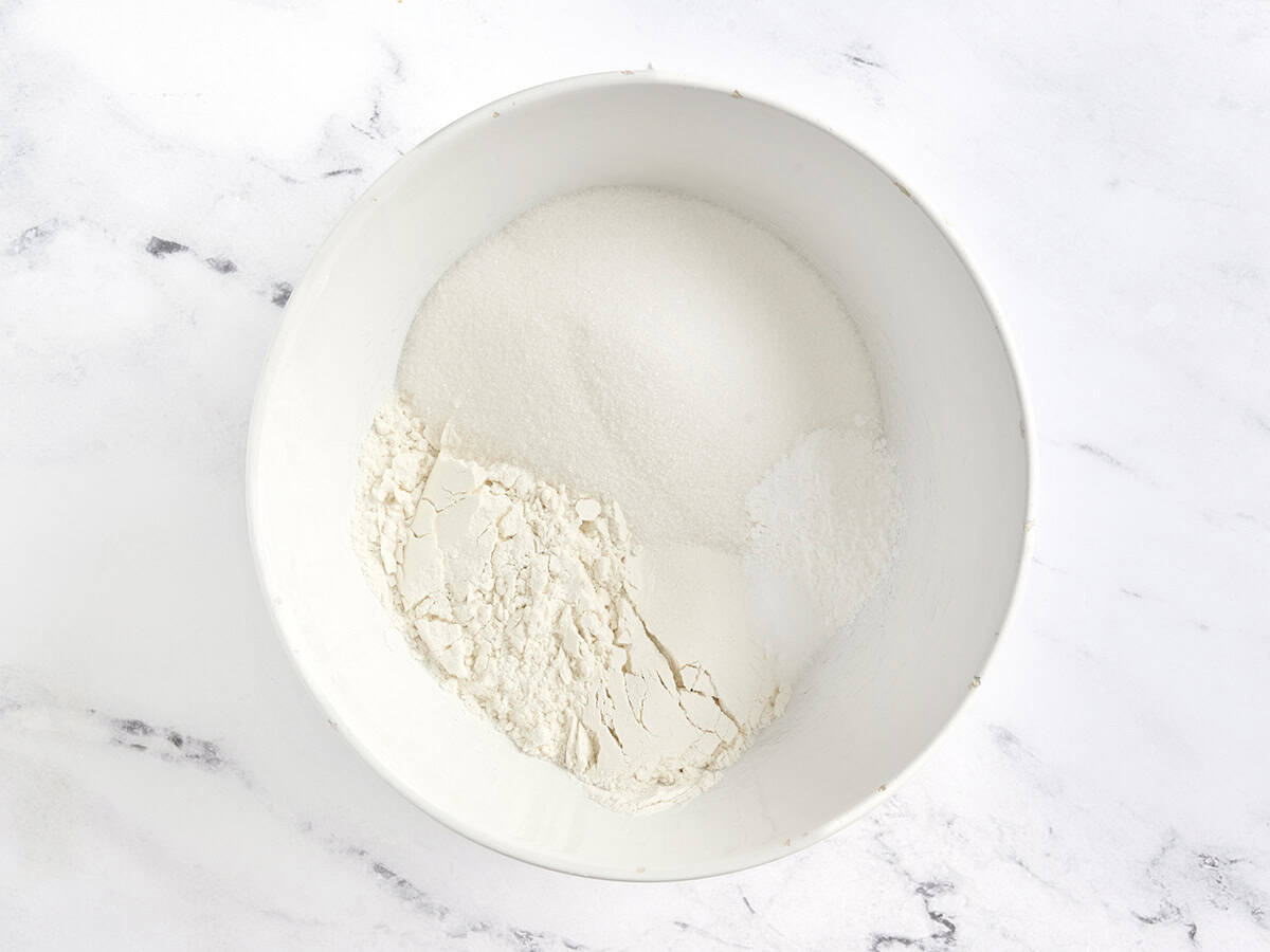 Mehl, Backpulver, Salz und granulierter Zucker in einer Mischschüssel.