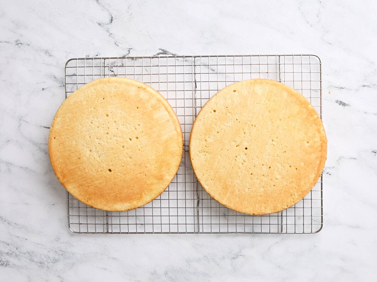 Zwei Vanille -Kuchen, die auf einem Kühlregal abkühlen.