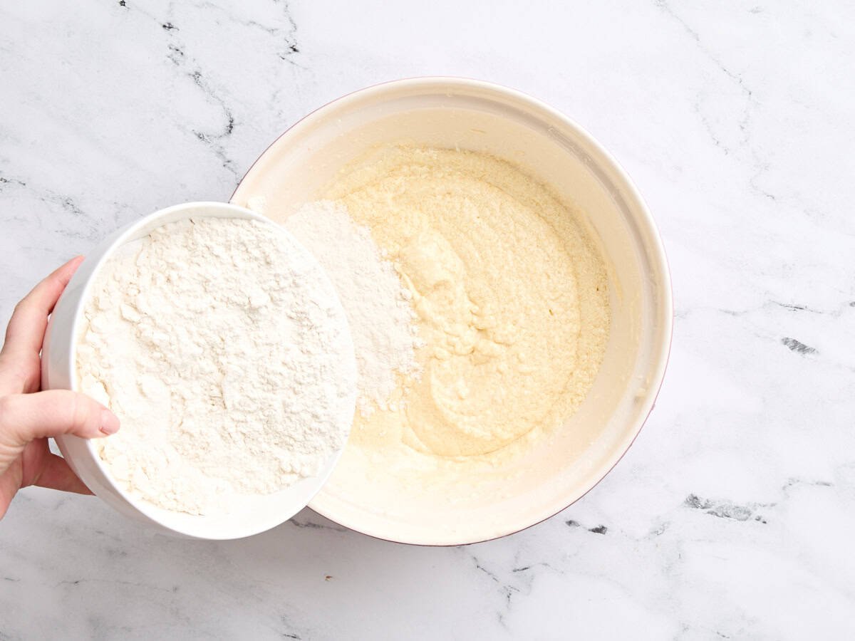 Die trockenen Zutaten werden mit den nassen Zutaten in einer Schüssel kombiniert, um Vanillekuchen zu machen.