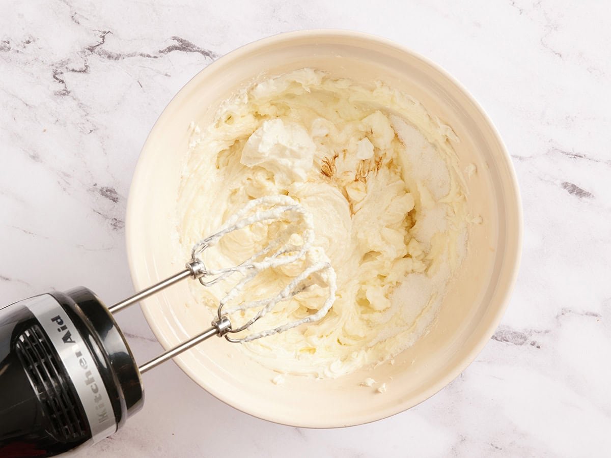 Käsekuchenfüllung mit einem Handmixer in eine Schüssel geben.