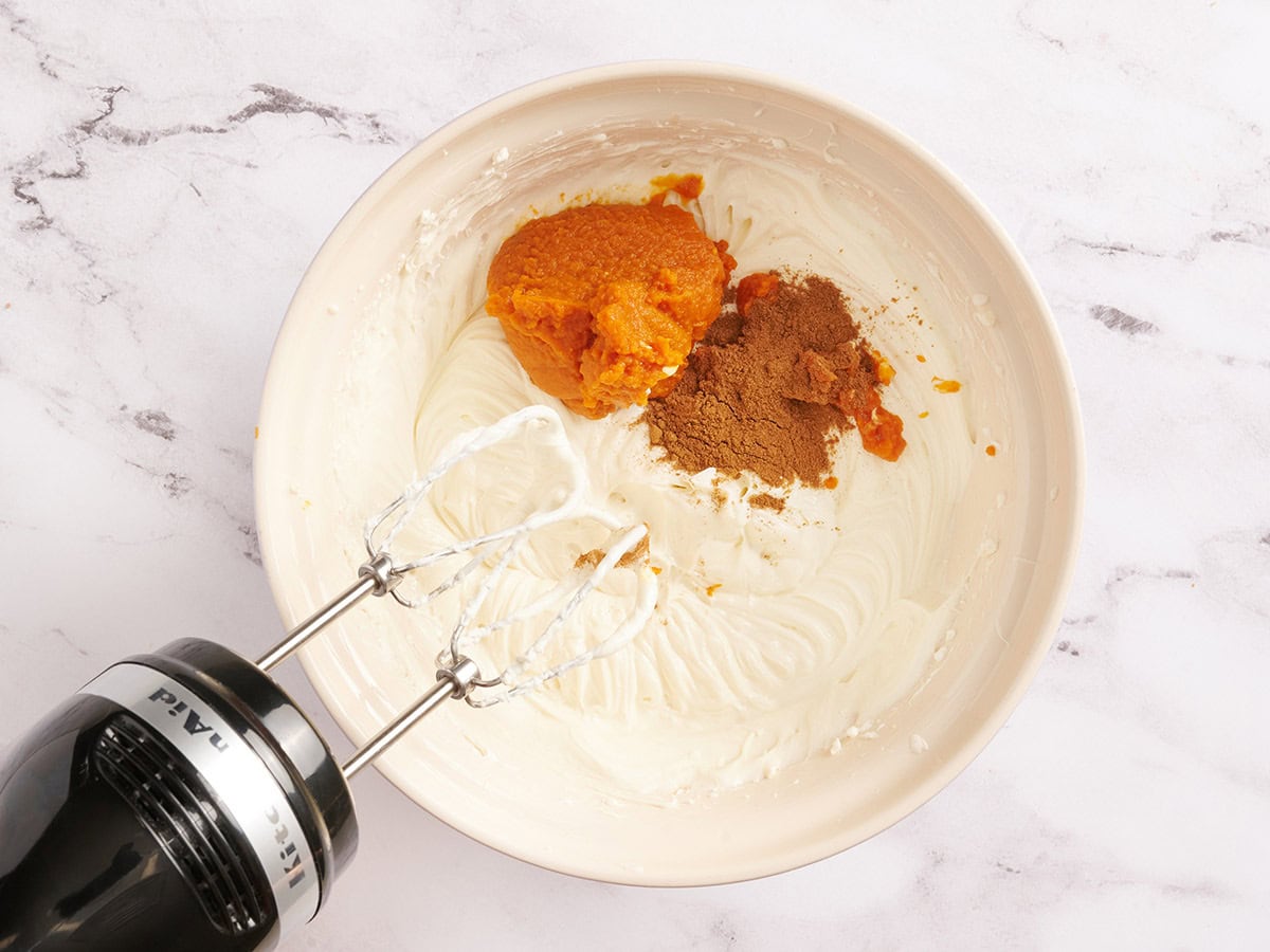 Kürbisgewürz und Kürbispüree in einer Schüssel mit Käsekuchenfüllung.