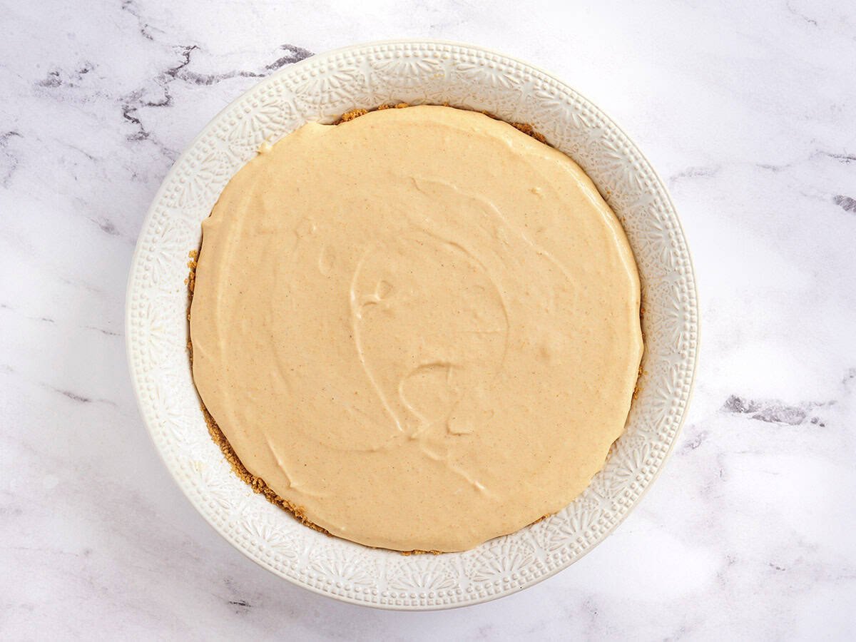 Kürbis-Käsekuchen in einer Kuchenform vor dem Backen.