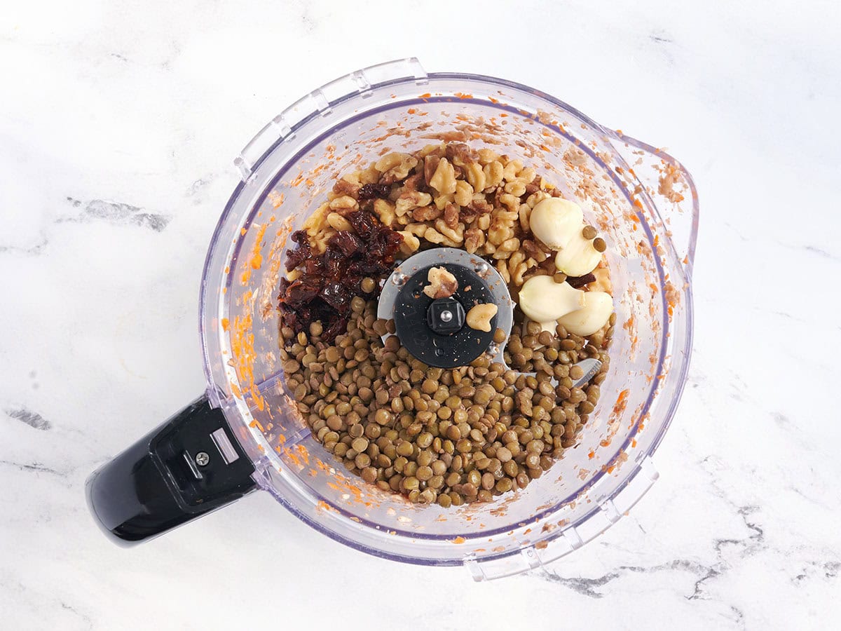 Knoblauch, Linsen, Walnüsse und sonnengetrocknete Tomaten in einer Küchenmaschine.