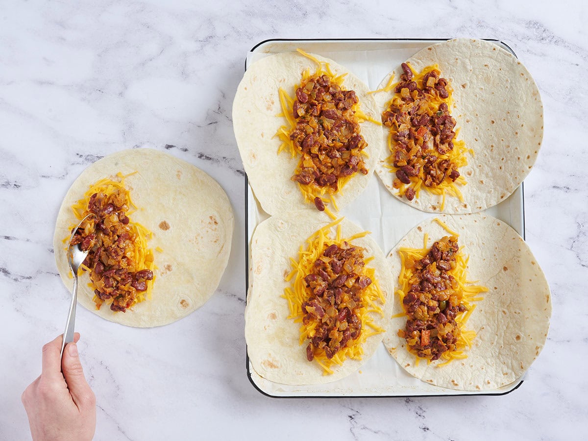 Mehl-Tortillas garniert mit geriebenem Cheddar-Käse und Bohnen.