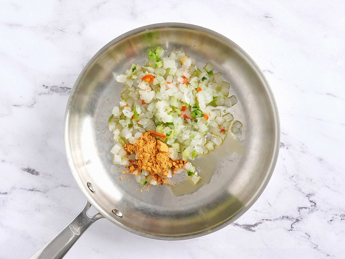 Gefrorenes gemischtes Gemüse und Taco-Gewürz in einer Pfanne.