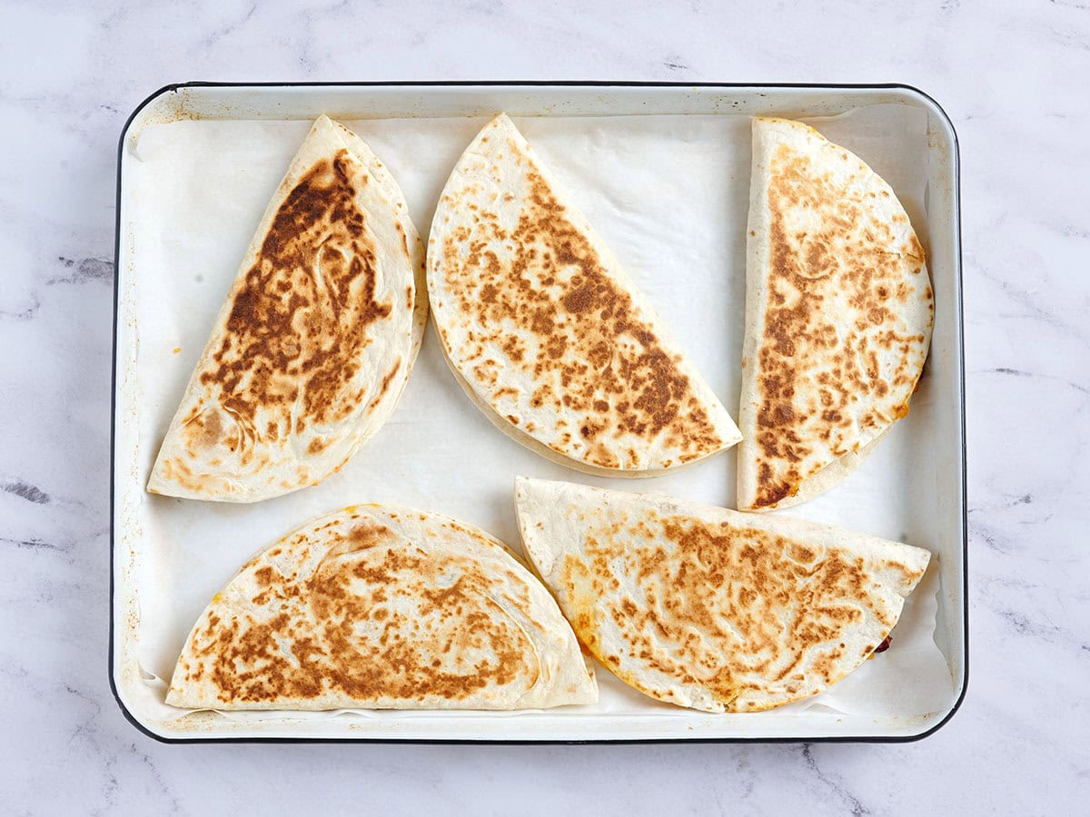 Fertige käsige Kidneybohnen-Quesadillas auf einem Backblech.