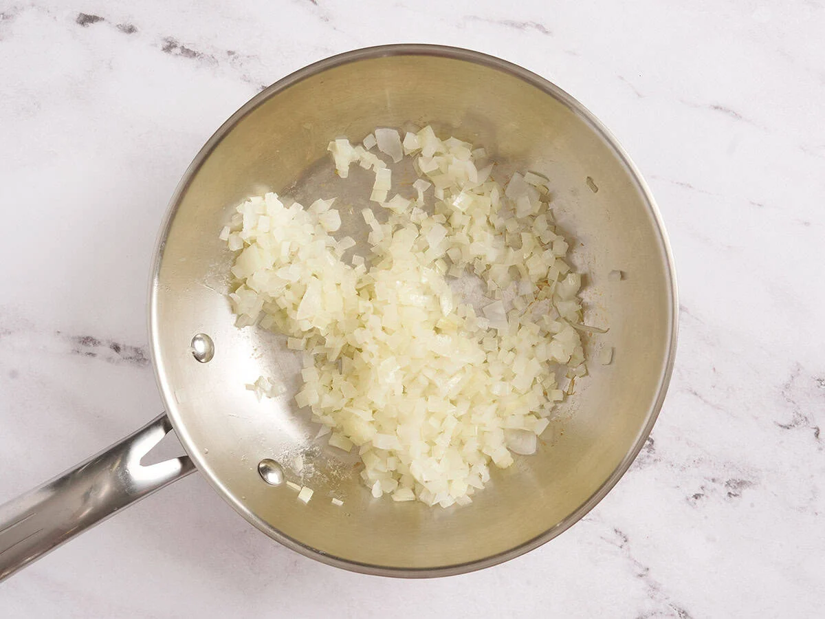 Zwiebeln in einer Pfanne anbraten.