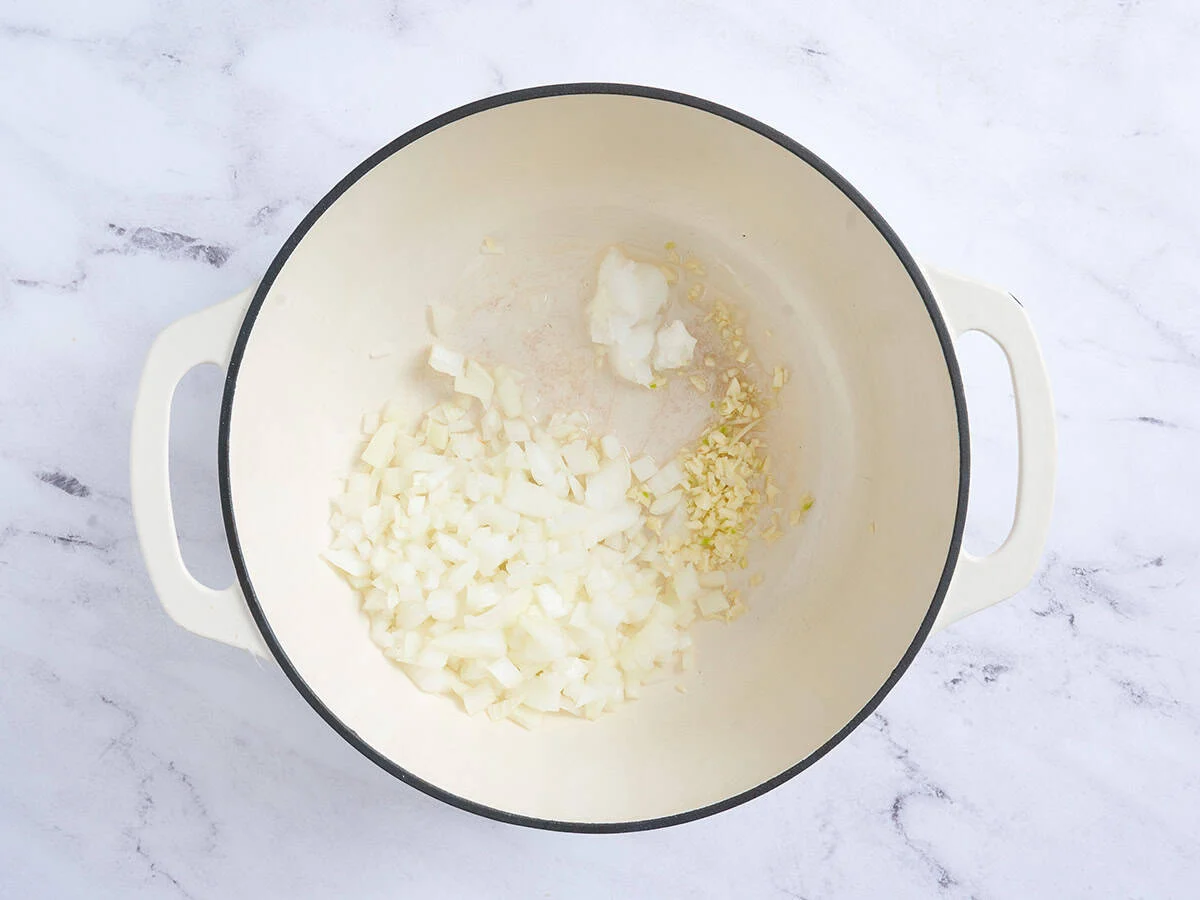 Zwiebeln und Knoblauch in einer Pfanne anbraten.