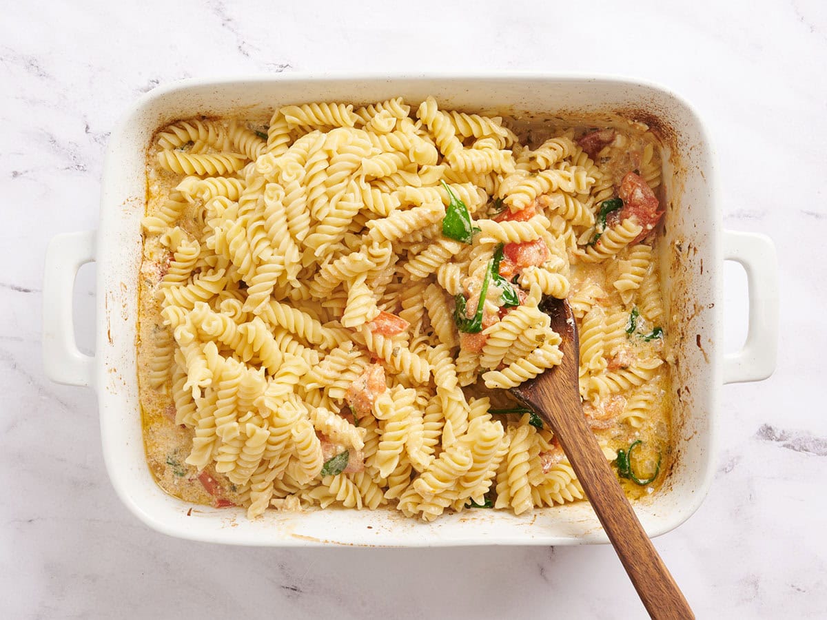 Rotini-Nudeln werden mit gerösteten Tomaten, Zwiebeln und Feta-Käse vermischt.