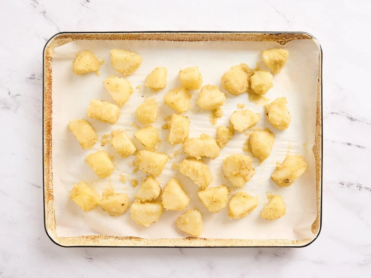 Kartoffeln auf einem mit Backpapier ausgelegten Backblech.