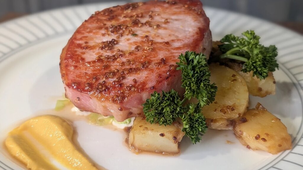 Trishas gebratenes, glasiertes Speckkotelett mit geschmortem Wirsing, Senf-Sahnesauce und gebutterten Babykartoffeln