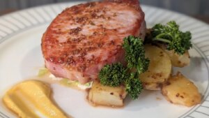 Trishas gebratenes, glasiertes Speckkotelett mit geschmortem Wirsing, Senf-Sahnesauce und gebutterten Babykartoffeln