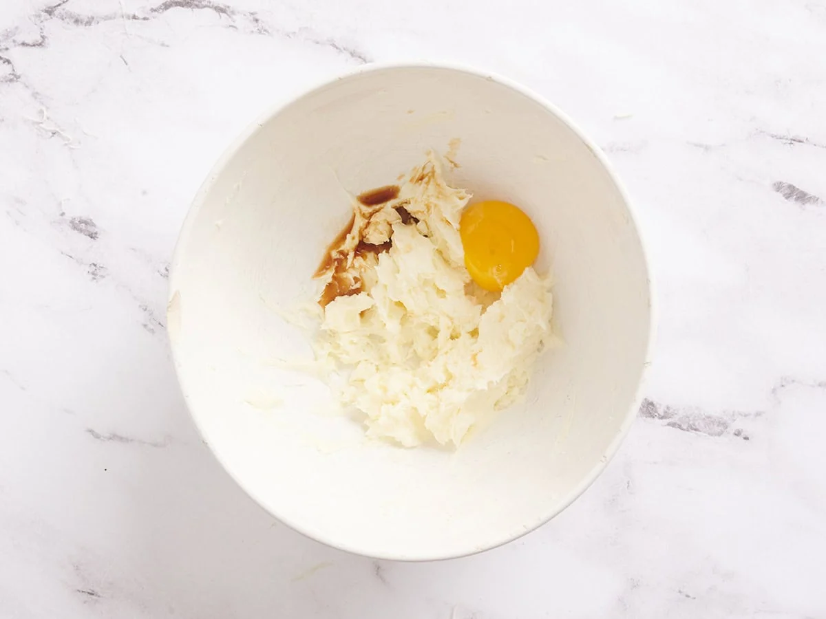 Ein Eigelb, das der Käsekuchenmischung für Karottenkuchenriegel hinzugefügt wird.