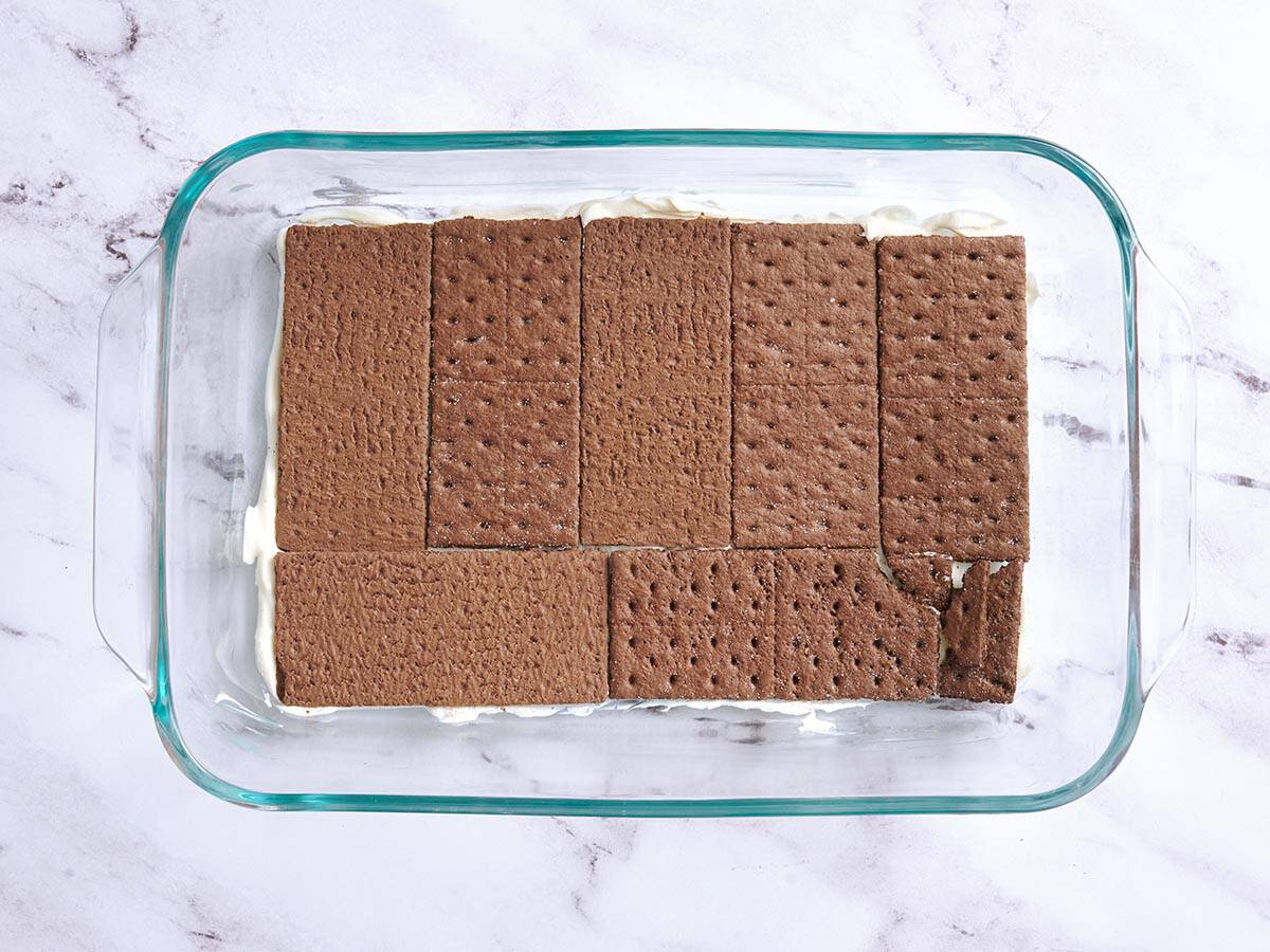 Eine Schicht Schokoladen-Graham-Cracker in eine Auflaufform geben.