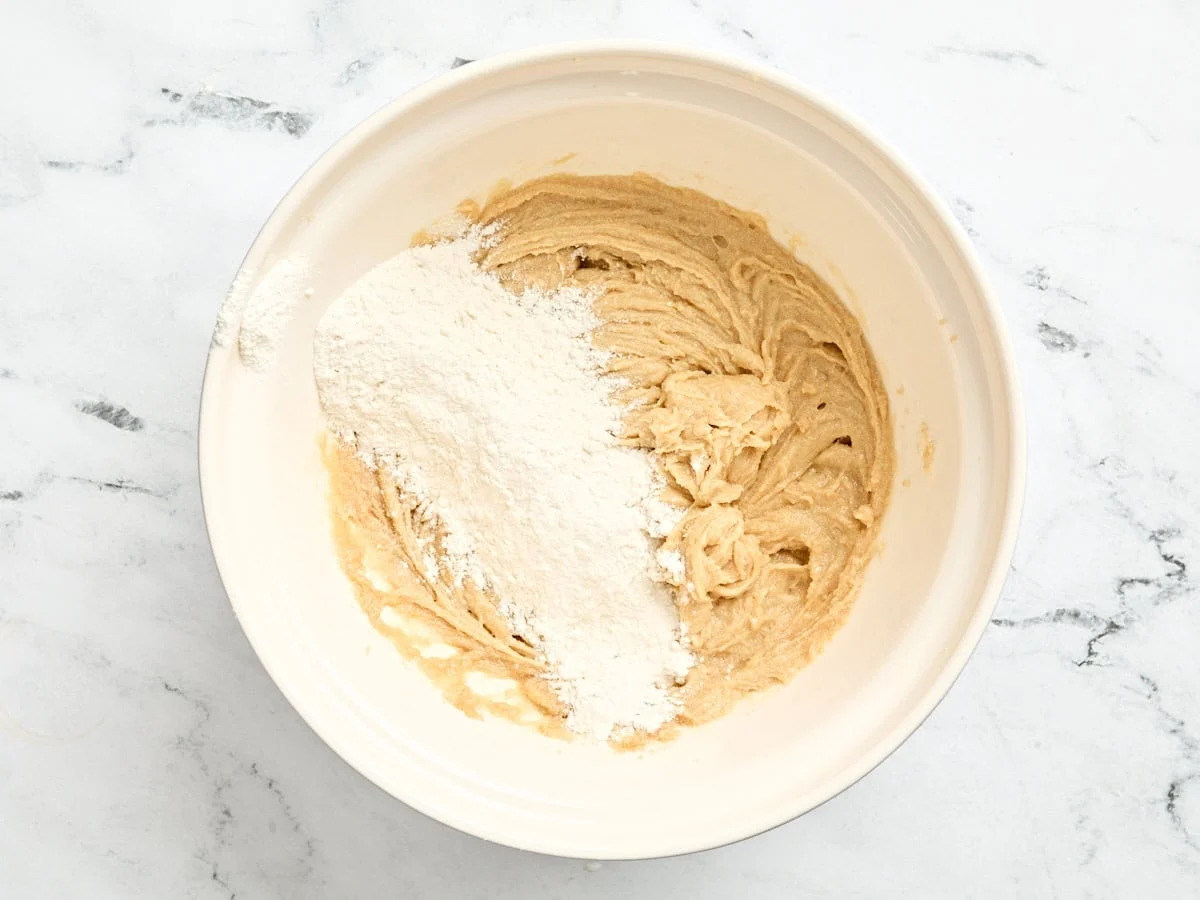 Etwas Mehl, Rahmbutter, Zucker und Eier in eine Schüssel geben.