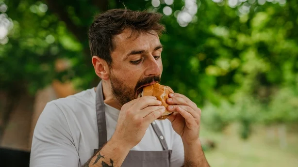 Mann genießt den Geschmack eines hausgemachten BBQ-Burgers
