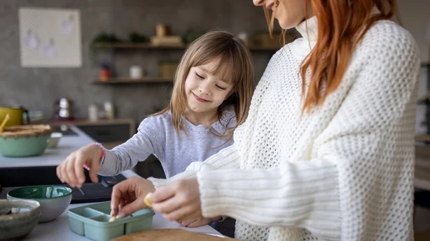Mutter und Tochter bereiten Essen zu