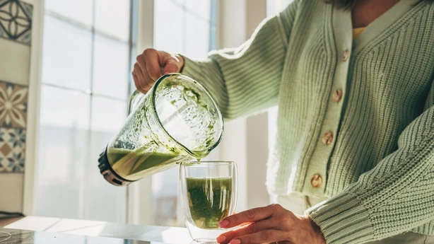 Junge Frau macht Detox-Smoothie 